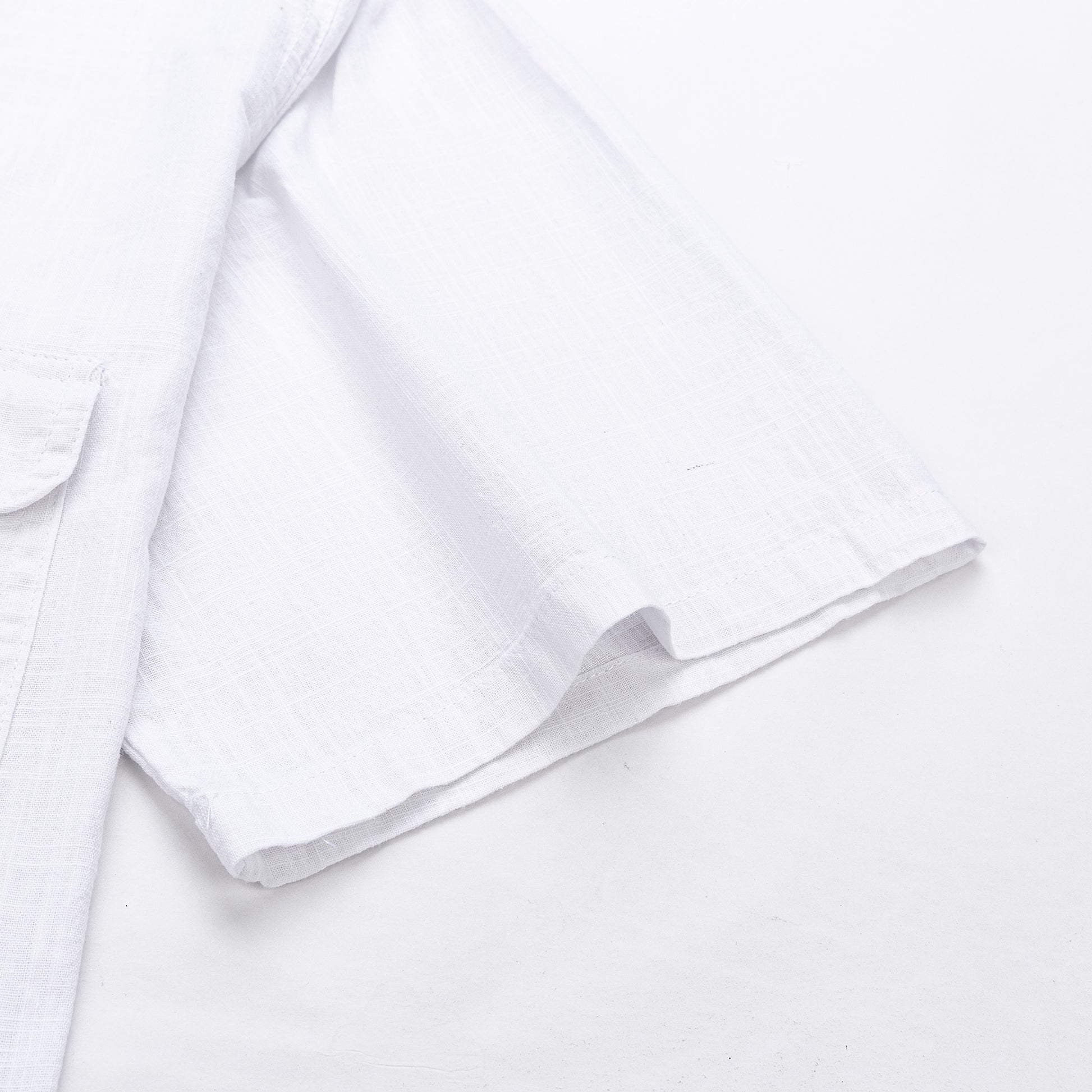 Ujj közelkép egy fehér lenvászon ingről